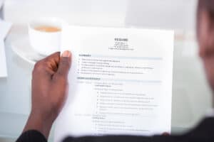 Close-up Of A Businessman Looking At Resume Holding In Hand