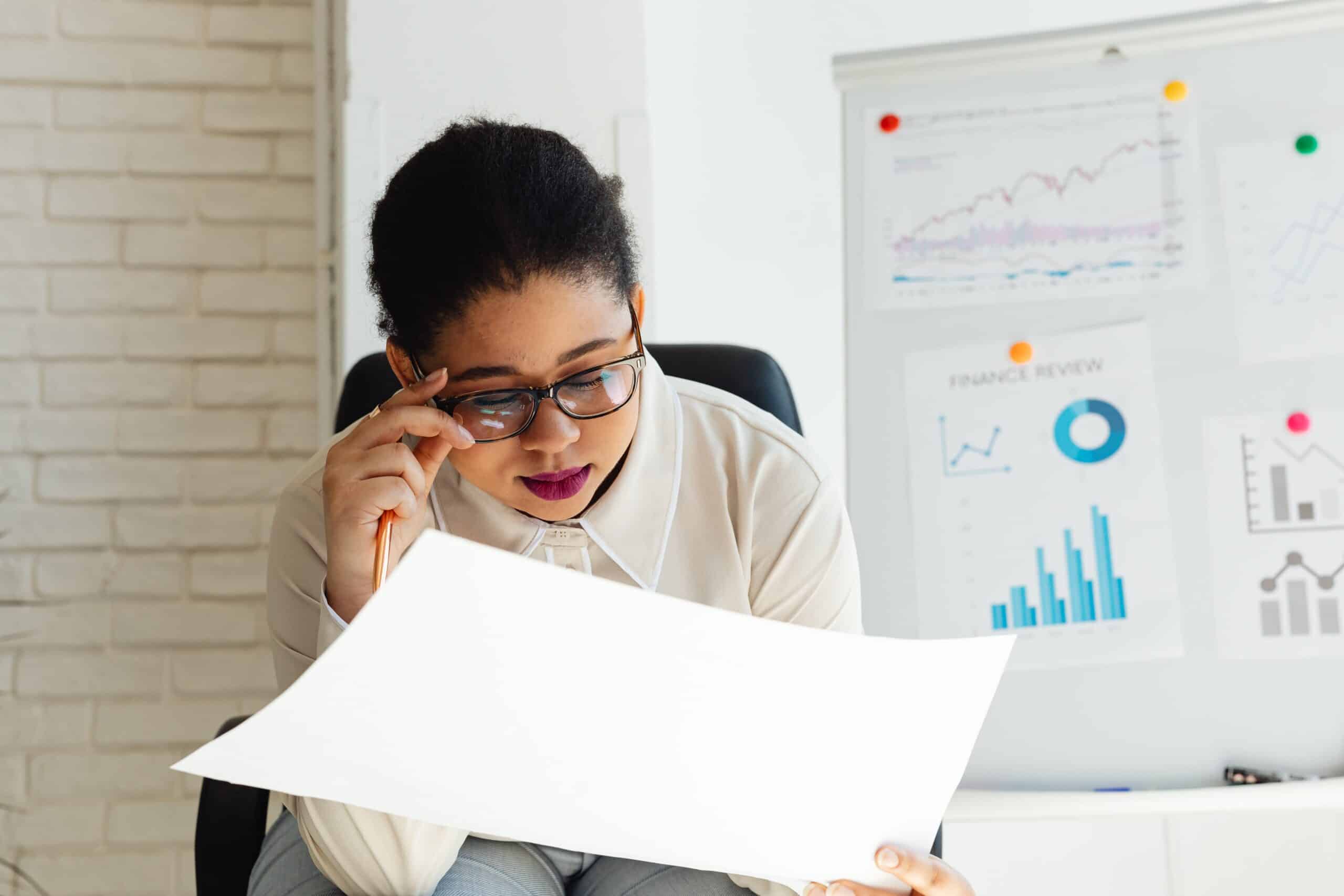 Woman thinking while looking at sheet of paper