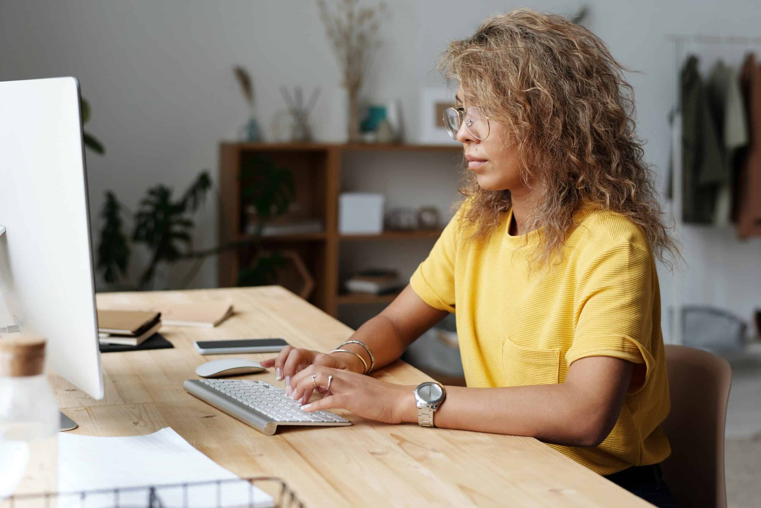 woman typing on keyboard while sitting at desk