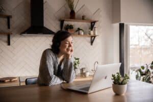 woman looking at laptop, smiling and answering software engineer interview questions