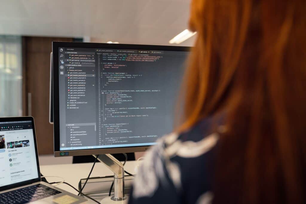 woman from behind looking at computer screen with software engineering code