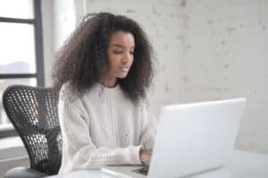 woman sitting at desk with laptop in front of her answering devops interview questions