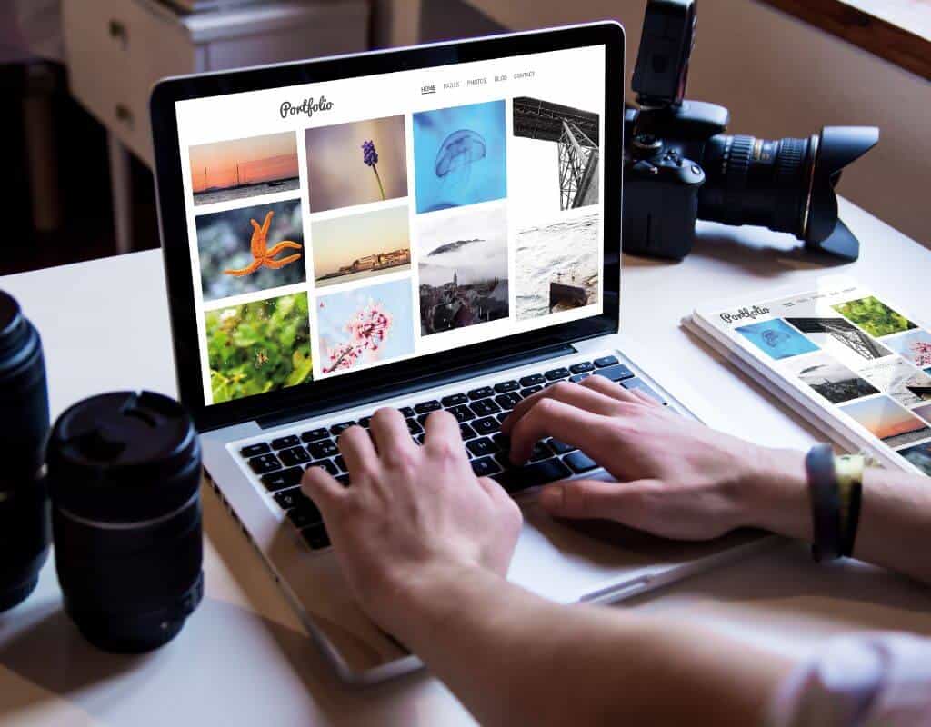 person typing on computer with online portfolio in front of them