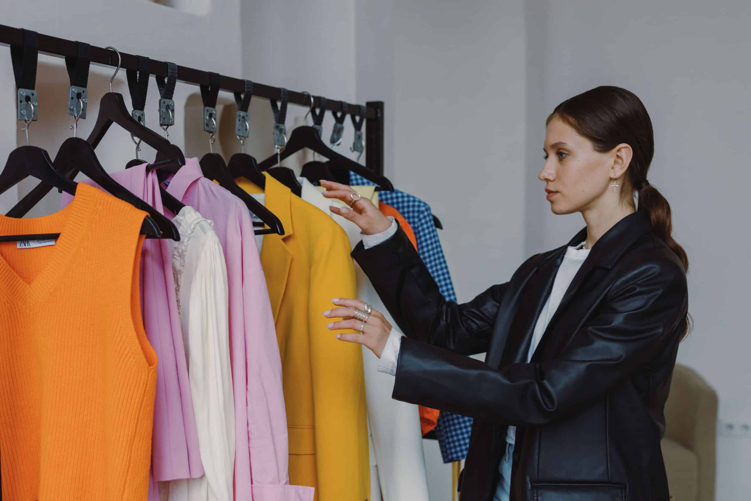 woman looking at clothing rack with various business attire items