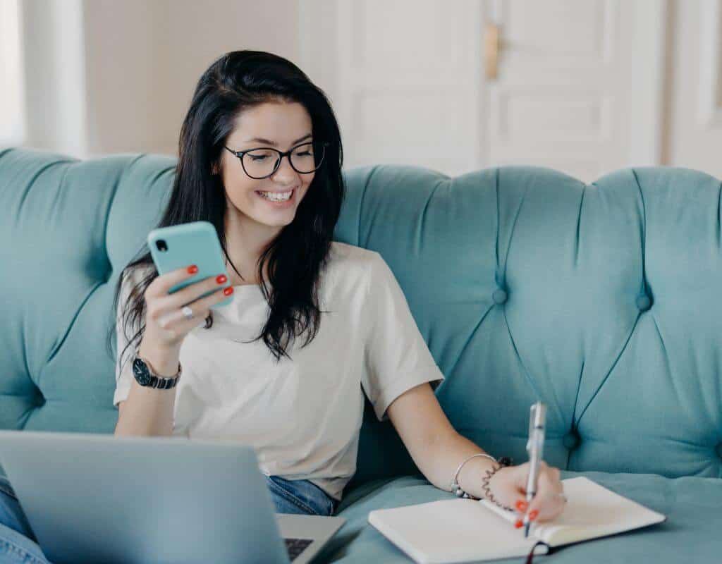 A woman showing what a remote job is by working on the couch