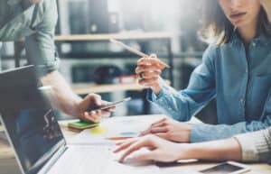 Businesspeople analyzing company standing using balance sheet financial statement