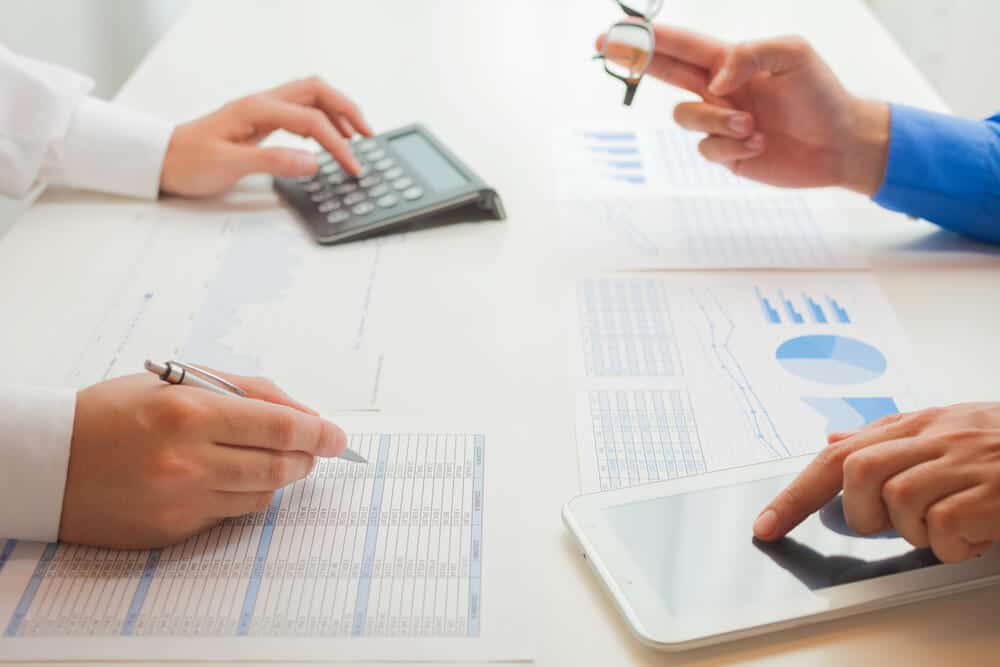Two businesspeople calculating and comparing internal rate of return for investment options