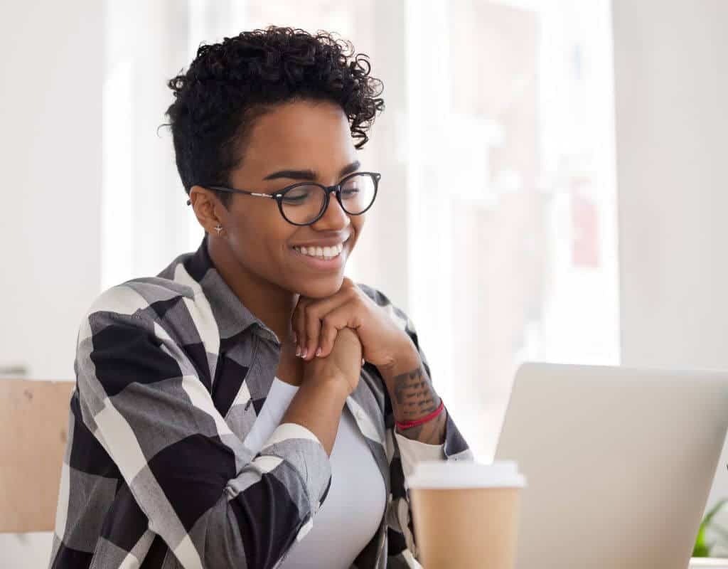 Student smiling while looking at laptop