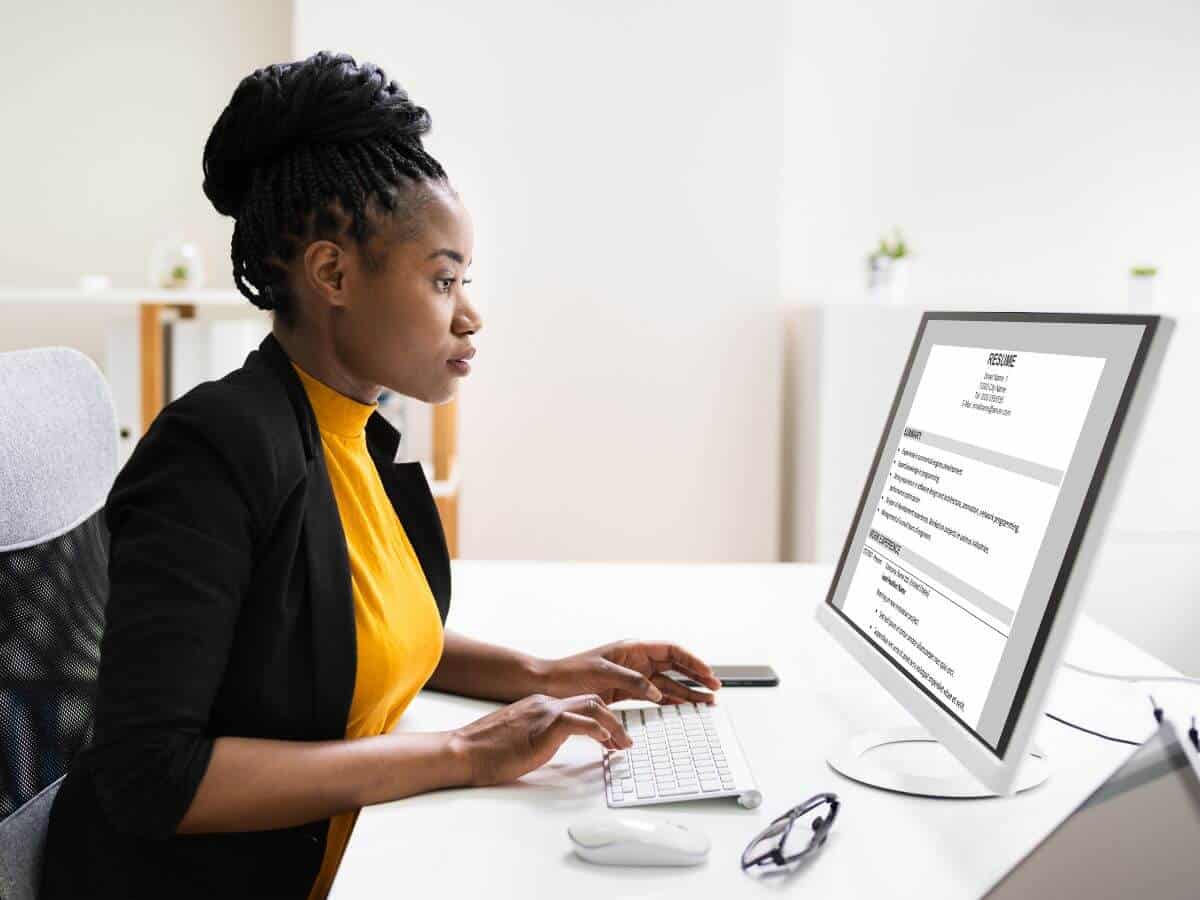 student sitting at desk typing resume for internship