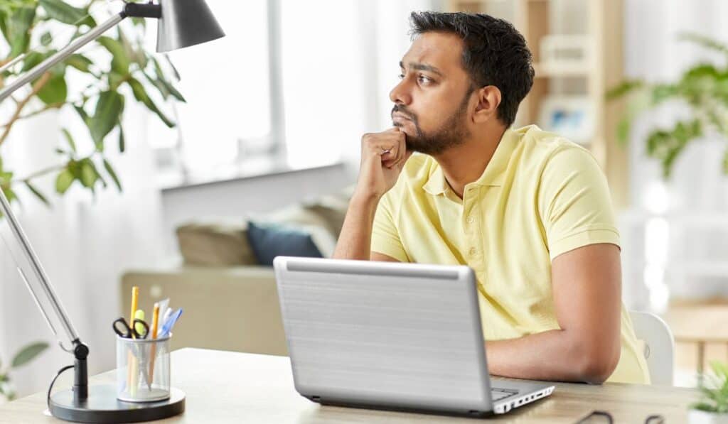 person sitting at laptop thinking